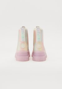 High-top sneakers with iridescent finish, pastel colors, padded collar, logo on the back, and chunky translucent soles.