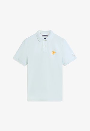Jasnoniebieska koszulka polo z krótkim rękawem, dwoma guzikami, żółtym haftowanym logo "TH" na piersi oraz małą flagą na rękawie.