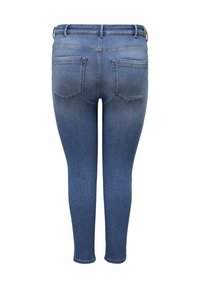 Úzké modré džíny vyrobené z denimu, které mají klasický design s pěti kapsami, vysokým pasem a mírně vybledlými místy pro zvýraznění textury.