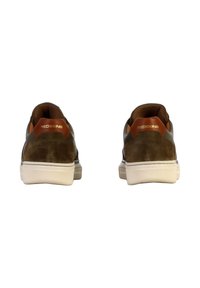 Un paio di sneakers in suede e pelle marrone con suole bianche, che mostrano la vista posteriore e il logo "REDSKINS" sul tallone.