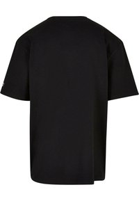 Tricou din bumbac negru, cu o croială lejeră, mâneci scurte și guler rotund. Spatele este simplu, fără logo-uri sau modele.