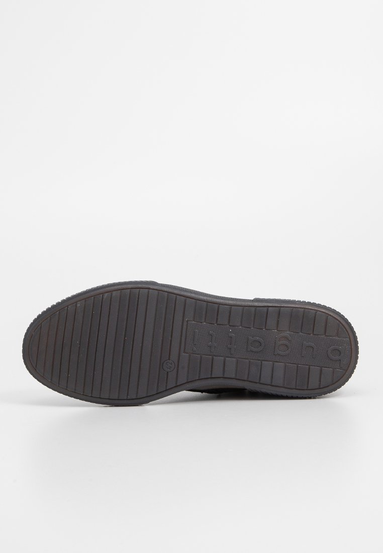 Suela de un zapato negro con surcos horizontales y el nombre de la marca "bugatti" grabado cerca del tacón sobre un fondo blanco.