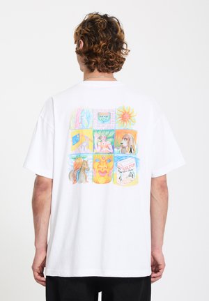 Personne portant un t-shirt blanc avec un graphisme coloré à neuf panneaux représentant le soleil, un chien, un cavalier et des visages abstraits dans le dos.
