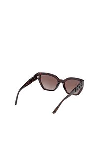 Schildpadbril met een hoekige cat-eye vorm, gradiënt bruine lenzen en decoratieve hardware op de pootjes. Strakke zwarte accenten zijn inbegrepen.