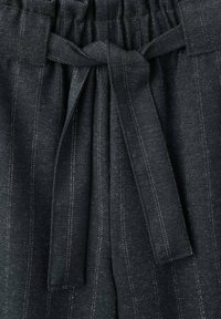 Tissu gris foncé texturé avec des fines rayures blanches verticales. Dispose d'une taille froncée et d'une ceinture à nouer en tissu à l'avant.