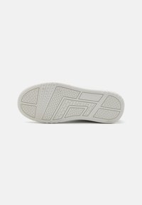 Semelle de sneaker blanche avec un motif texturé. Les caractéristiques comprennent des designs géométriques et des rainures pour une meilleure adhérence. Matériau lisse avec une finition soignée.