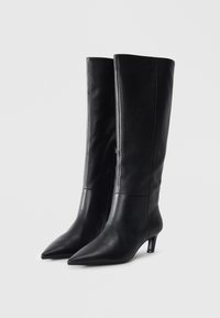 Black leather knee-high boots with a pointed toe and a slim, low heel. Smooth texture with visible stitching and a side zipper detail.