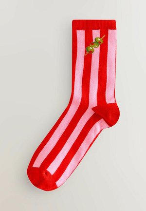 Röda och rosa randiga strumpor med en slät struktur och rundad tå, med grön olivbrodyr vid mitten.
