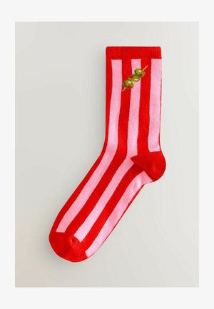 Röda och rosa randiga strumpor med en slät struktur och rundad tå, med grön olivbrodyr vid mitten.