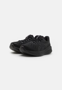 Scarpe sportive nere con un superiore testurizzato, punta arrotondata e suola ammortizzata. Le caratteristiche includono perforazioni e un logo del marchio discreto sul lato.