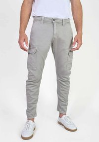 Lichtgrijze cargobroek met twee zijzakken, taps toelopende pasvorm, katoenen mengsel en een knoopsluiting. G gedragen met witte sneakers.