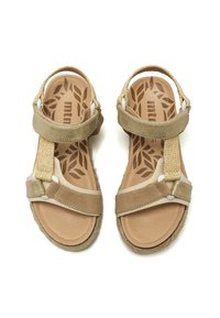 Sandalias beige con correas texturizadas, plantilla acolchada y cierres ajustables. Suelas de goma y plantilla con patrón de hojas.