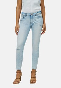 Pantalones vaqueros skinny de denim azul claro con cintura alta, que cuentan con bolsillos delanteros y detalles desgastados en las rodillas. Con cierre de botón.
