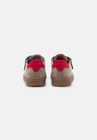 Scarpe basse in suede marrone con dettagli rossi sul tallone e sulla linguetta, dotate di suola in gomma e cerniere laterali per una facile calzata.