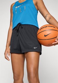 Svart mesh basketballshorts med elastisk midje og snøring, kombinert med en blå tanktop med fargerik "FLY" tekst.