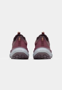 Maroon hiking shoes with a textured upper, reinforced heel, and light gray speckled sole. Includes pull tabs and durable tread pattern.