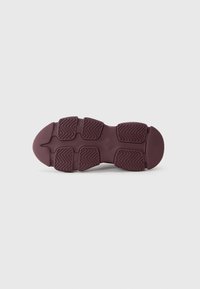 Semelle de chaussure en caoutchouc bourgogne foncé, présentant un motif texturé avec des rainures alternées et des accents circulaires pour une meilleure adhérence.