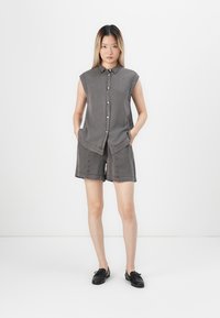 Grå denim ermeløs skjorte med krage, frontlukking med knapper og shorts; har en avslappet passform med sidelommer og minimal søm.