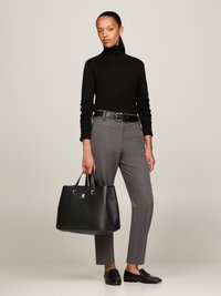 Svart høyhalset genser, grå skræddersydde bukser, svart lærhåndpose med strukturert finish og sølvfarger hardware, svarte loafers.