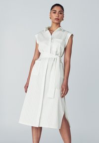 Weiß gestreiftes Kleid mit kurzen Ärmeln, Knopfleiste vorne, Taillengürtel und seitlichen Taschen. Der Stoff wirkt glatt mit einem eleganten, taillierten Design.