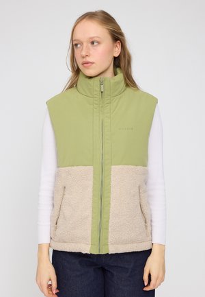 Green and beige sleeveless vest featuring a soft, textured lower section, smooth upper section, side pockets, and a high collar.