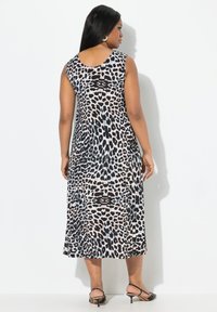 Robe à motif léopard avec design sans manches. Fabriquée en tissu léger, elle présente une jupe évasée et un encolure ronde. Motif noir et beige.