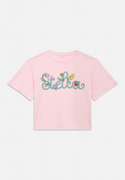 Svijetloružičasti cropped top kratkih rukava s natpisom "Stella" u zelenim pisanom slovima ukrašenim šarenim cvijećem i malim crvenim rajčicom.