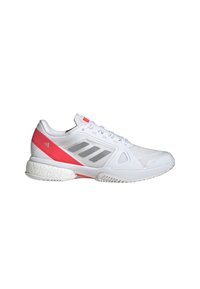 White athletic shoe with pink accents, made of a textured mesh and synthetic materials, featuring a rubber sole and three grey stripes.
