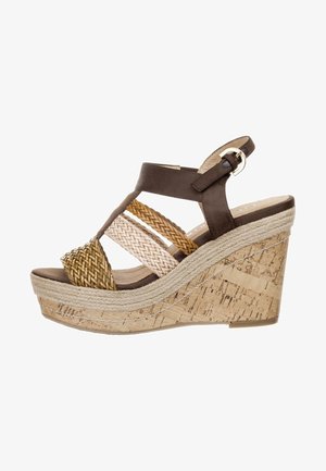 Sandale compensée avec une semelle en liège, des brides en simili cuir marron et des accents tressés en beige et marron clair. Elle dispose d'une bride de cheville réglable.
