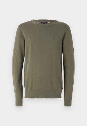 Olivenfarget strikkegenser med rund hals, ribbestrikkede mansjetter og kant. Liten logo aksent på brystet. Myk tekstur og tettsittende design.