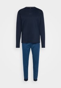 Camisa de manga longa azul-marinho com um logótipo discreto no peito, combinada com calças azuis estampadas com punhos canelados e uma textura suave.