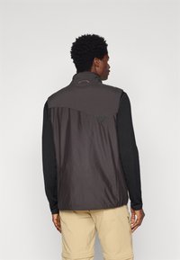 Chaleco sin mangas para hombres en gris oscuro con un alto cuello, que presenta un panel trasero en gris claro y detalles de malla cerca de los hombros.