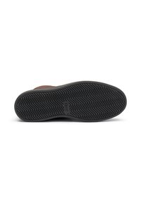 Suela de zapato de goma negra con un patrón en zigzag, que presenta un acabado suave y un logo estampado. Ligeramente elevada, proporciona tracción y flexibilidad.