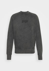 Ciemnoszara bluza dresowa o luźnym kroju, z prążkowanymi mankietami i dołem oraz okrągłym dekoltem. Na górnej części pleców znajduje się czarne logo "DRYKORN".