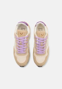 VEJA sneakers med en beige tekstiloverdel med suedede accenter, lilla snører og logodetaljer. Svarte gummisåler med teksturert grep.