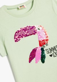 Jasnozielony t-shirt z krótkim rękawem, z wielokolorową, cekinową grafiką homara oraz czarnym napisem "SUMMER LOVE".