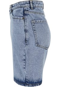 Shorts en denim bleu clair avec un délavage. Présente une coupe droite, un design à cinq poches et des coutures visibles le long des coutures.