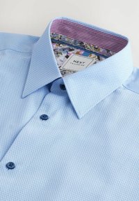 Világoskék, textúrázott ing, mintás belső gallérral, sötétkék gombokkal és "NEXT TAILORING" felirattal.