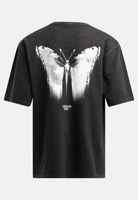Schwarzes Baumwoll-T-Shirt mit einem großen weißen Schmetterlingsgrafik auf dem Rücken, Rundhalsausschnitt und kurzen Ärmeln mit genähten Details.