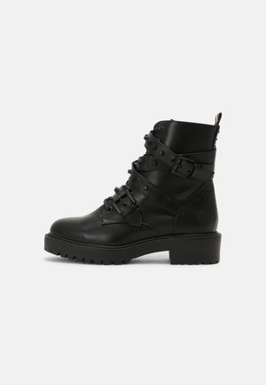 Schwarze Lederstiefeletten mit mehreren Riemen, Schnallen und dekorativen Nieten. Verfügt über eine robuste Sohle und einen stabilen Absatz.