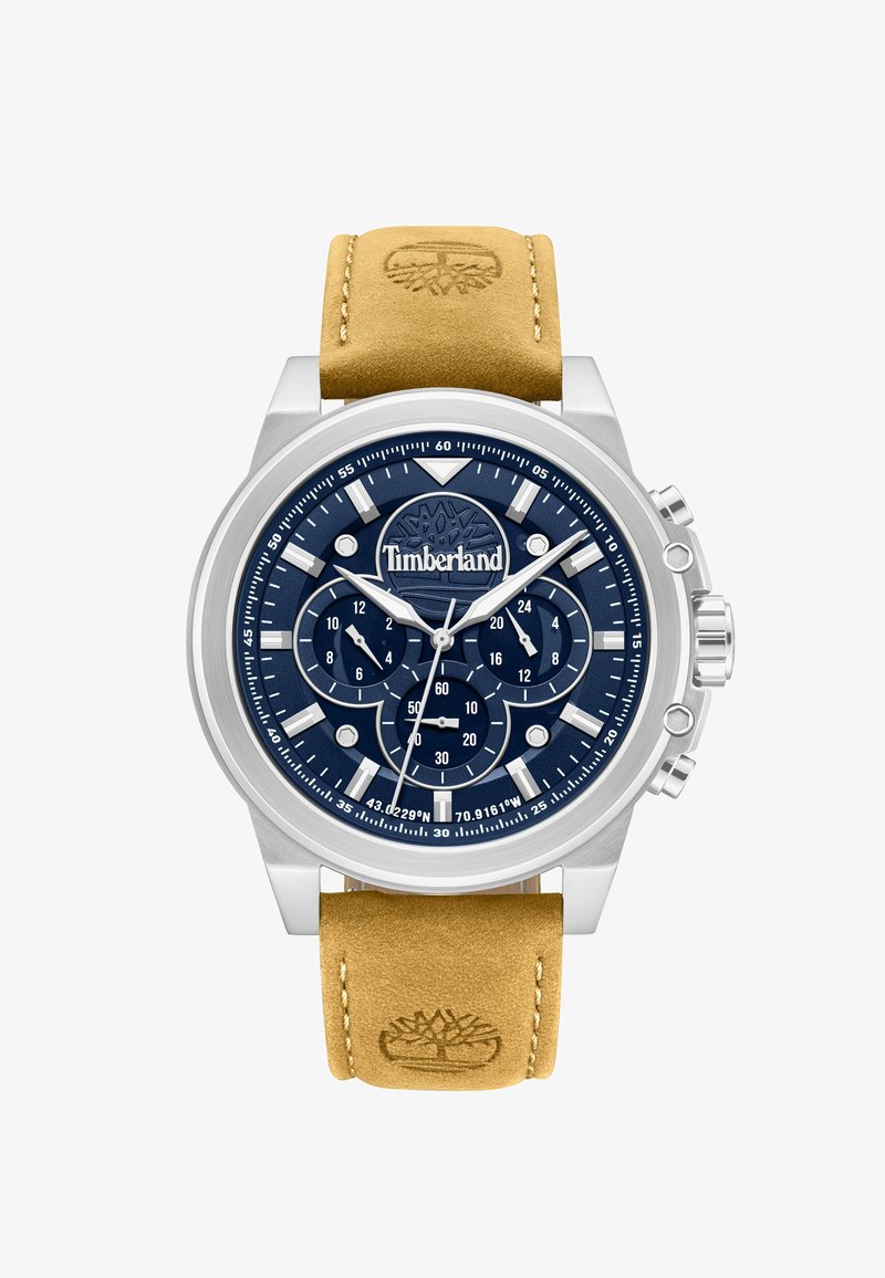 Orologio cronografo con quadrante blu navy, indici e lancette argentati, cinturino in pelle color cuoio con logo dell'albero in rilievo e marchio Timberland sul quadrante.