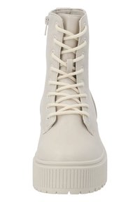 Bottes beige à lacets en cuir lisse, avec une semelle côtelée et une fermeture éclair latérale pour un enfilage facile.