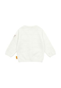 Maglione bianco a maglia con motivi testurizzati, polsini e orlo a coste, e una piccola toppa decorativa sulla manica superiore.