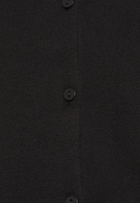 Svart cardigan med mjuk textur, med flera svarta knappar och en slät stickad design. Enkel, klassisk stil utan ytterligare mönster.