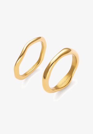 Dos anillos de oro con formas irregulares y superficies lisas y pulidas, cada uno grabado con "SINGULARU" en la banda interior.