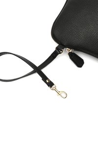 Čierna kožená kabelka s textúrovaným povrchom, zlatou kovovou časťou a odnímateľným pásom s uzáverom. Zipsové uzatvorenie na vrchu.