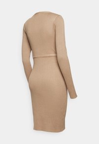 Robe longue à manches longues en maille côtelée beige avec taille cintrée et ourlet mi-long, vue de dos sur un mannequin.