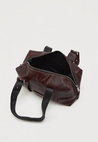 Mala de couro bordô com fecho de zíper, apresentando alças pretas e um interior espaçoso. Exterior texturizado e detalhes sutis de costura.