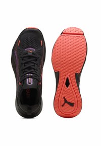 Chaussures de sport noires avec une tige texturée, des accents violets et orange, et une semelle en caoutchouc rose à motifs. Conçues pour le confort et la performance.