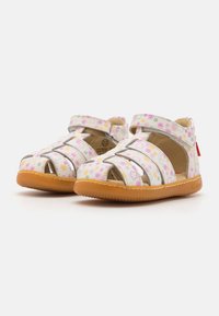 Sandali per bambini bianchi con motivo floreale in rosa, giallo e verde. Presentano punta aperta e cinturini superiori regolabili. Suola in gomma.